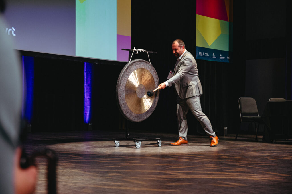 A photo of a Dries Moreels hitting a large gong